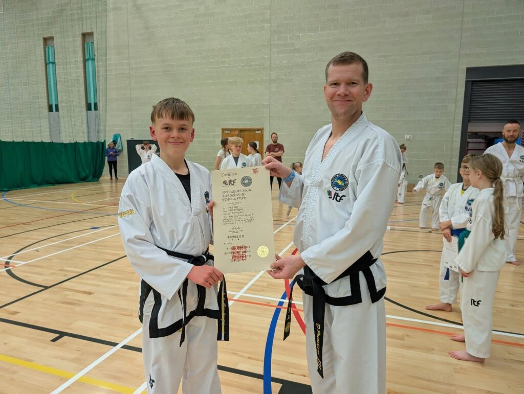 Taekwon-Do instructor presenting a grading certificate to student