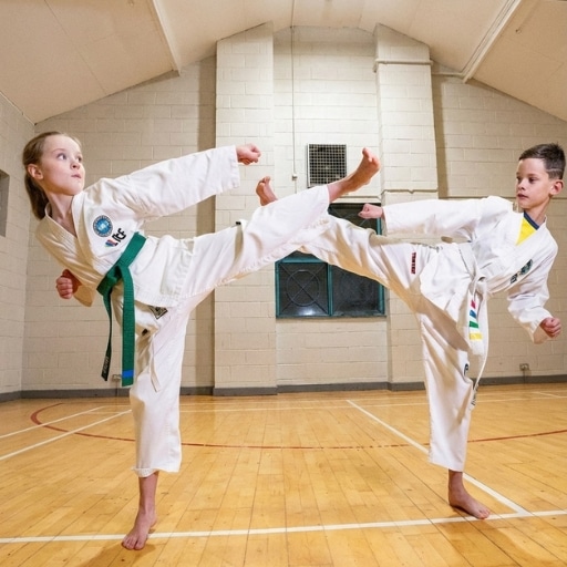 Junior Taekwon-Do students practising kicks during children’s martial arts class.